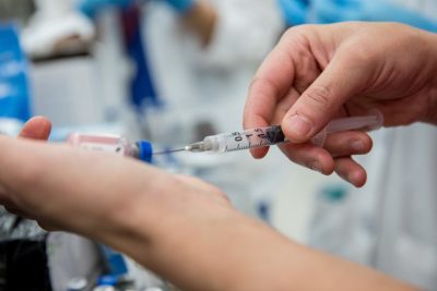 Syringe pulling medicine out of a vial.