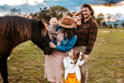 Kaitlyn McBane with her family and a horse.