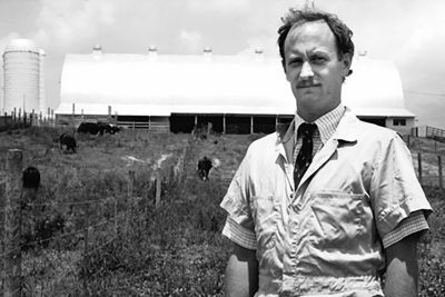Black and white photo of Terry Swecker standing in a field. 