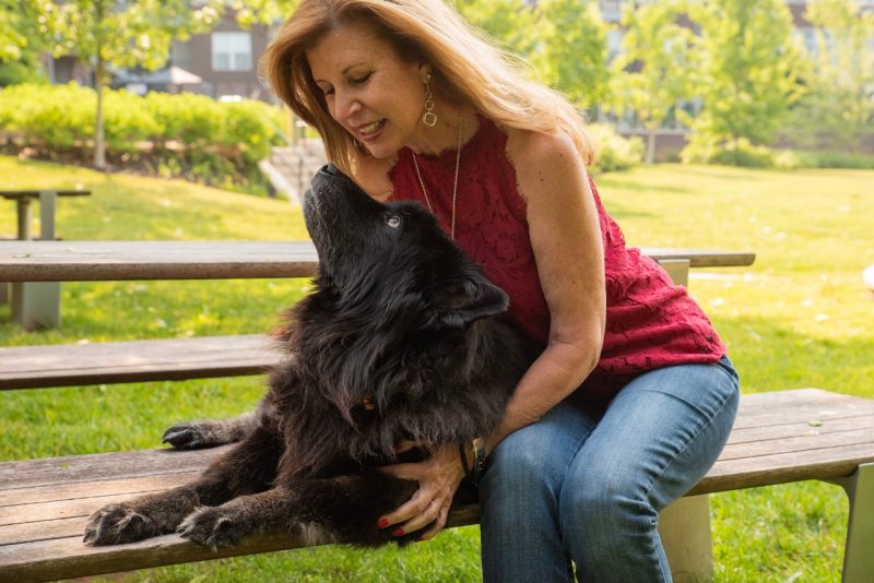 Maryanne Pagonis (at right) and Rosie laying on a picnic table.