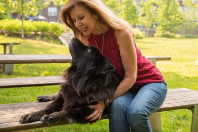 Maryanne Pagonis (at right) and Rosie laying on a picnic table.