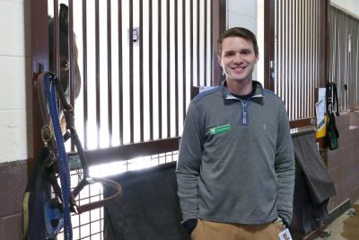 Zach Kirkpatrick stands in front of a stall at the equine medical center barn.