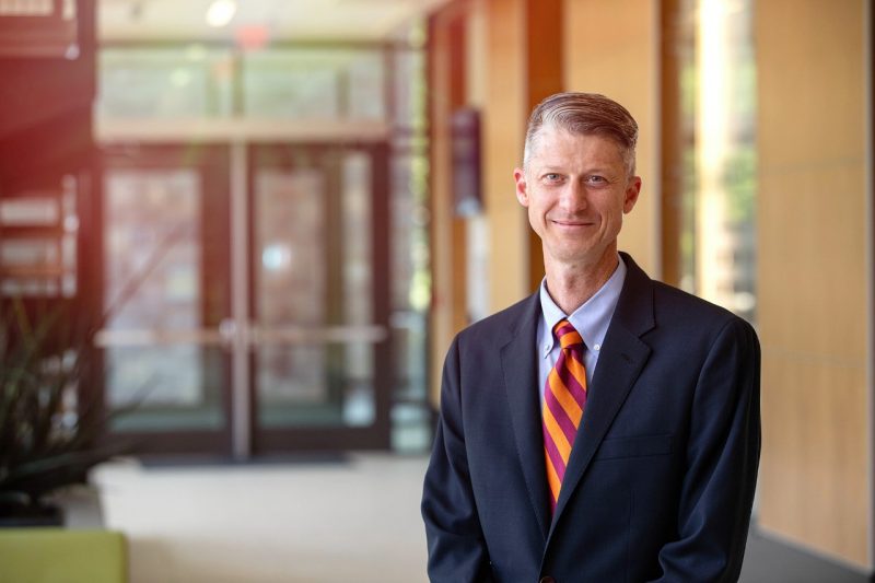 Portrait of Chris Byron, associate professor , standing in an office environment.