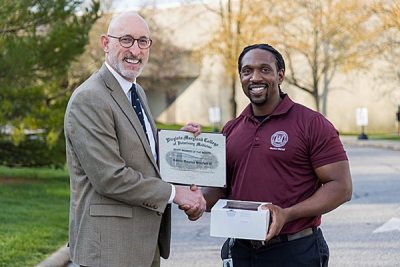 Dean Dan Givens presents the April 2023 Staff Member of the Month award to Maurice Mitchell.