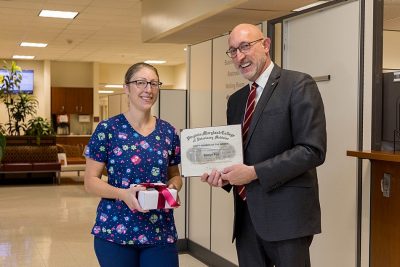 Dean Dan Givens presents the October 2023 Staff Member of the Month award to Robyn Fox.