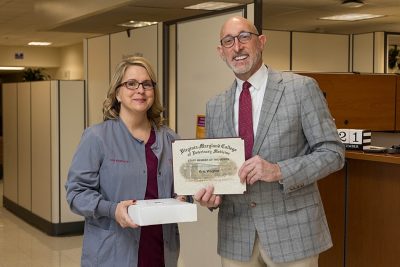 Dean Dan Givens presents the December 2023 Staff Member of the Month award to Kris Wagher.