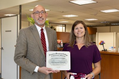 Dean M. Dan Givens presenting the July 2024 Staff Member of the Month award to Amy Alexander-Husband.