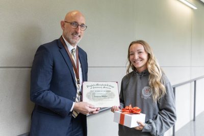 Dean Dan Givens presents the September 2024 Staff Member of the Month award to Delaney Wilson.