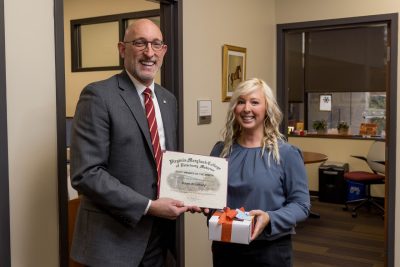 Dawn Bradbury (at right) receiving the Staff Member of the Month award for November of 2024 from Dean M. Dan Givens (at left).