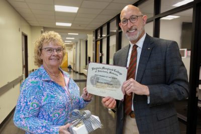 Dean Dan Givens presents the April 2024 Staff Member of the Month award to Sharon Carbaugh.