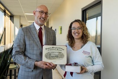 Dean Dan Givens presents the February 2024 Staff Member of the Month award to Karisa Barton.