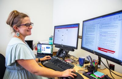 Rachel Miles, research impact librarian, is sitting at her desk scrolling through a computer screen full of research citations.