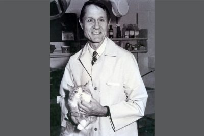 A black and white photo of Dr. Kent Roberts holding a cat