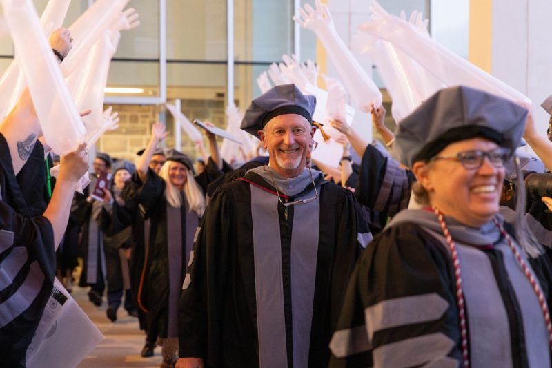 Terry Swecker (center) at the May 2024 DVM Commencement Ceremony.