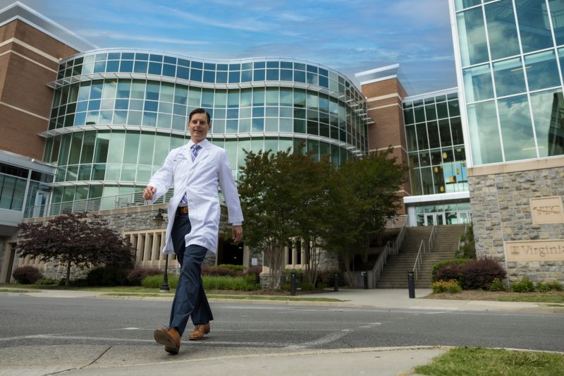 Alumnus Matt Joy walks in front of the Virginia Tech Carilion School of Medicine building in Roanoke.