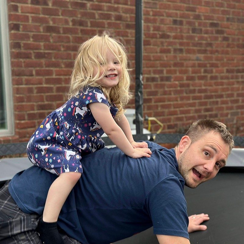 Parent and child on a trampoline.