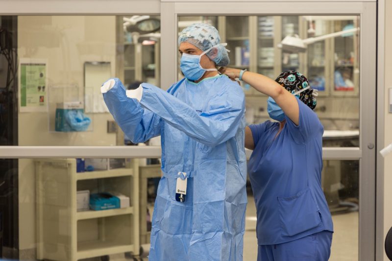Students help each other scrub in for surgery