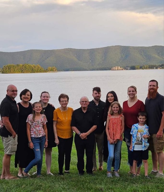 Family standing in front of a lake.
