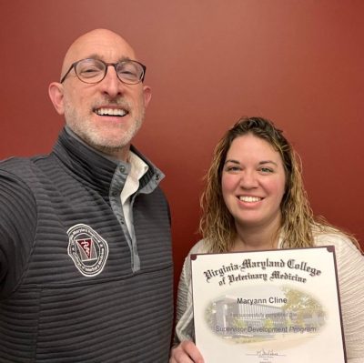 Two people taking a selfie with a certificate.
